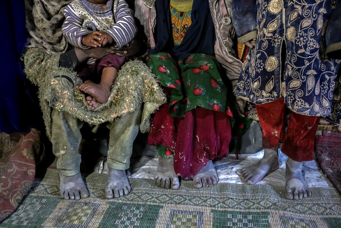 아프가니스탄 카불 외곽의 난민 대피소에서 사람들이 추위에도 맨발로 앉아있다.(사진=EPA, 연합뉴스) 