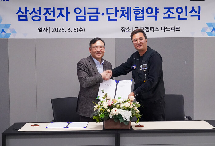 최완우 삼성전자 디바이스솔루션(DS)부문 부사장(왼쪽)과 손우목 전국삼성전자노동조합 위원장이 5일 열린 조인식에서 합의서를 교환하며 악수하고 있다. (사진=삼성전자 제공)