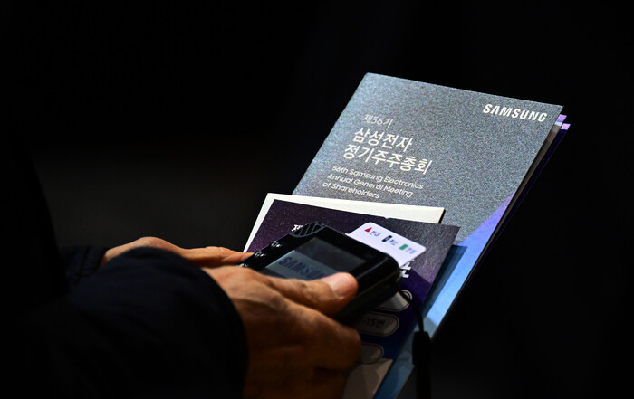 삼성전자 주주가 19일 경기 수원시 영통구 수원컨벤션센터에서 열린 제56기 정기주주총회에 참석해 자료를 꼭 쥐고 있다. (사진=연합뉴스)