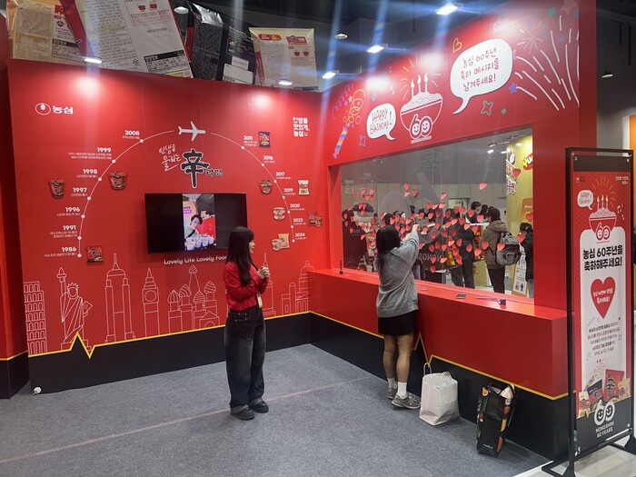 농심 60주년 축하메시지를 작성한 관람객이 스티커를 부착하고 있다. (사진=서용하)