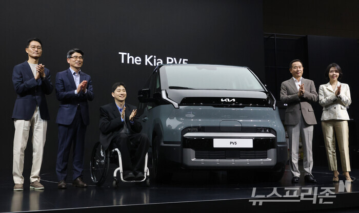 기아차 경영진과 박위씨가 무대에 올라 PV5 옆에서 박수치고 있다. 왼쪽부터 서하준 기아 국내상품실장, 송호성 기아 사장, 박씨, 정원정 기아 국내사업본부장, 이향은 LG전자 상무. (사진=이정우)