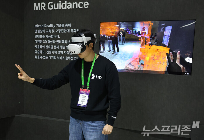 HD현대 직원이 서울모빌리티쇼가 열리고 있는 경기 고양 킨텍스 전시장에서 MR글래스를 착용한 채 굴착기의 고장 부위를 진단하고 있다. (사진=이정우)