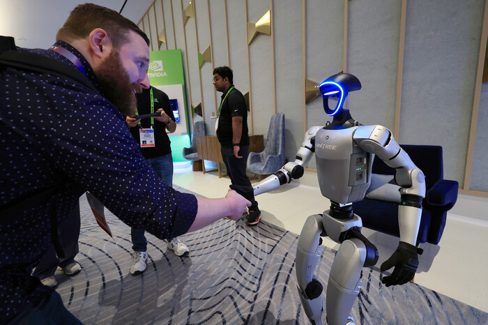 세계 최대 가전·정보기술(IT) 전시회 CES 2025가 열린 지난 1월7일(현지시각) 미국 네바다주 라스베이거스 퐁텐블루 호텔 엔비디아 전시관에서 휴머노이드 로봇 유니트리 G1이 관람객과 악수하고 있다. (사진=연합뉴스)