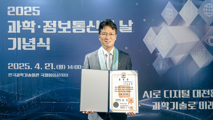 도승용 SK하이닉스 부사장이 21일 과학의날 기념식에서 한덕수 대통령 권한대행한테서 동탑산업훈장을 받은 뒤 훈장증을 들어보이고 있다. (사진=SK하이닉스 제공)