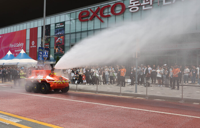 무인 소방로봇이 직사포로 물을 뿜어내는 모습을 시민들이 지켜보고 있다. (사진=연합뉴스)
