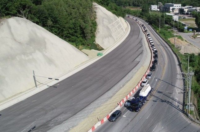 위험도로 개선공사가 거의 완료됐지만 기존도로와의 단차로 인한 위험 문제로 마무리 공사를 앞두고 공사가 전면 중지됐다. 기존도로를 지나는 차량들의 불편이 이만저만이 아니다. 사진은 성신양회 앞에서부터 차량정체 현상이 벌어지고 있는 모습을 드론촬영한 모습이다. 만약 현재 상태로 공사가 완료될 경우 이 구간의 차량정체가 극심할 것으로 예상된다.                               사진=독자제공
