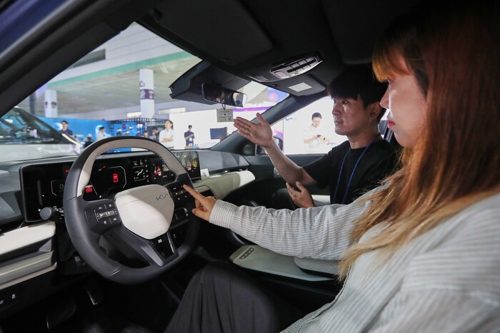 관람객이 AI가 적용된 EV4 차량 내부에서 AI 어시스턴트 기능을 체험하고 있다. (사진=현대차그룹 제공)