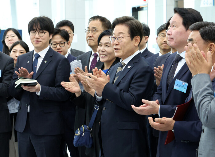 이재명 대통령이 지난 20일 울산전시컨벤션센터에서 열린 AI 글로벌 협력 기업 간담회 뒤 AI 제품·서비스 시연을 참관하며 박수치고 있다. 하정우 AI미래기획수석(앞줄 맨 왼쪽)도 함께 박수치고 있다. (사진=연합뉴스)