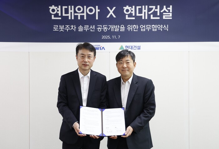 지난 7일 열린 로봇주차 설루션 공동 개발 관련 업무협약식에서 양사 관계자들이 기념사진을 찍고 있다.