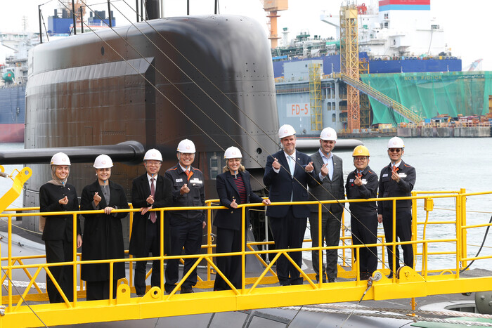 멜라니 졸리 캐나다 산업부 장관(가운데)이 24일 한화오션 거제사업장을 방문해 김희철 한화오션 대표(왼쪽 넷째) 등과 장영실함을 배경으로 단체사진을 찍고 있다. (사진=한화오션 제공)  